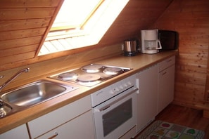 A compact kitchen with a gas stove, a sink, and a microwave. - Holiday apartment with 1 bedroom (Osteel)