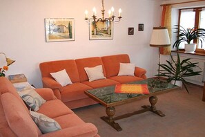 Ein Wohnzimmer mit einer Couch, einem Couchtisch, einer Lampe und einer Zimmerpflanze.