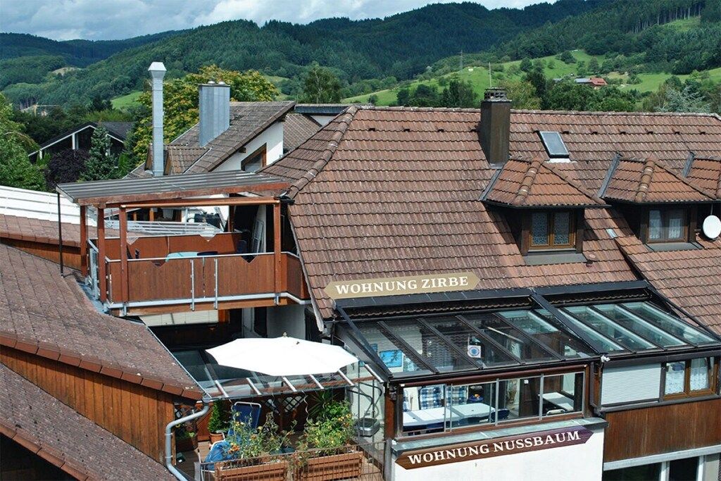 A building with a sign 'WOHNUNG ZIRBE' and 'WOHNUNG NUSSBAUM' indicating residential units.