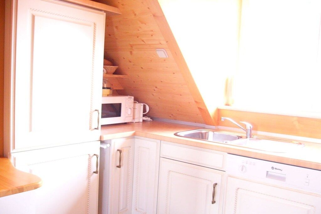A kitchen with white cabinets, a microwave, and a sink.