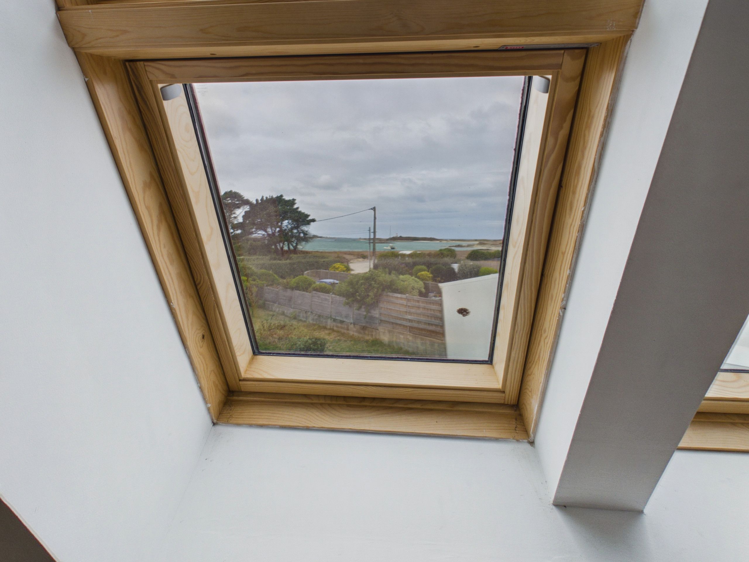 A skylight with a view of a coastal landscape.