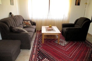 Ein Wohnzimmer mit Sofa, Sessel und Couchtisch.