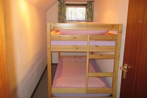 Ein Stockbett mit einem Fenster darüber.