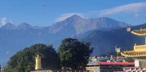 A mountainous landscape with a traditional building featuring a golden spire.