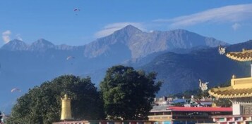 A mountainous landscape with a traditional building featuring a golden spire.