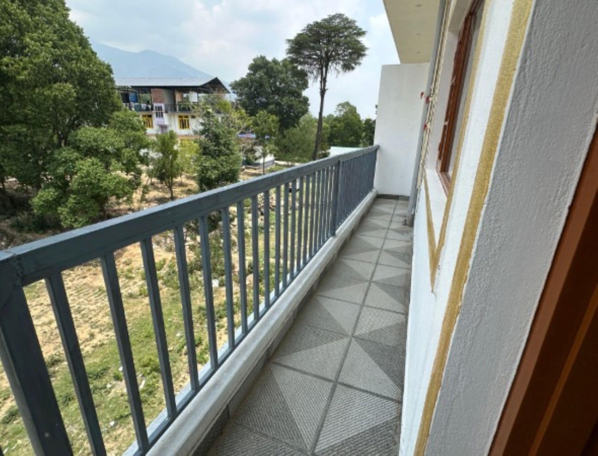 A balcony with a view of a mountain and trees.