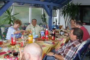 A group of people dining at an outdoor table with various food items and drinks. - Holiday apartment with 1 bedroom (Schleusingen OT Hinternah)