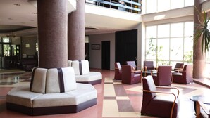 A spacious lobby with a checkered floor, seating areas, and large windows allowing natural light. - GRAND PALACE HOTEL (Bartın)