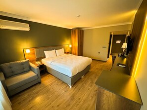 A hotel room with a bed, a chair, a desk, and a mirror. - GRAND PALACE HOTEL (Bartın)
