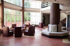 A spacious lobby with a high ceiling, large windows, and a central column. - GRAND PALACE HOTEL (Bartın)