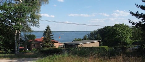 A residential area with a view of a lake, a small building, and a paved path.