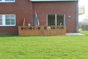 A brick house with a wooden fence, a patio with a table and chairs, and a sliding glass door. - Open the door and off we go Barendorf (Barendorf)