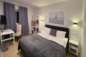 A hotel room with a bed, a desk, a chair, a wardrobe, and a painting on the wall. - Landhotel Rauber Sankt Wendel Double Room (Oberthal)