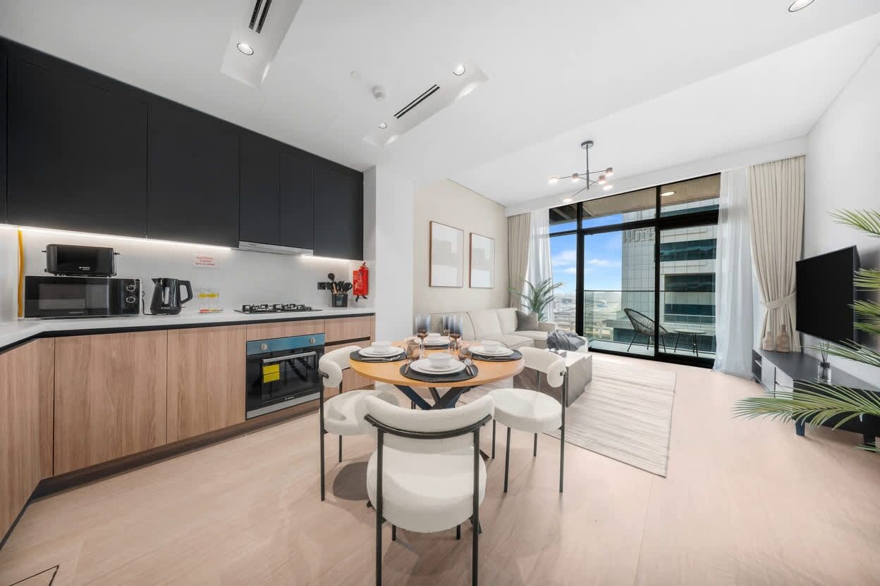 Una cocina moderna con comedor, ventanas amplias y un televisor de pantalla plana.