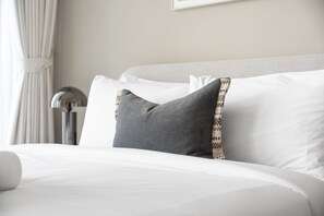 A neatly made bed with white linens and a single gray pillow with a patterned edge. - StayShort - Chic 1 Bedroom Unit in Dubai Marina that Sleeps 4! (Dubai)