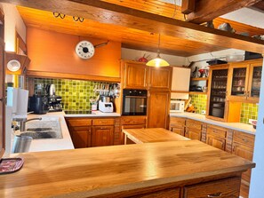 A kitchen with wooden cabinets, a microwave, and a coffee maker. - Le Bouquetin en Redingote Chalet: Mountain View, Wi-Fi, Air Conditioning (Aussois)