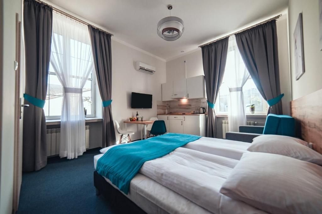 Une chambre d’hôtel équipée d’un lit, d’un bureau, d’une chaise et d’une kitchenette.