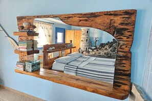 A bedroom with a bed, a wooden headboard, and a shelf with books. - Villa in Pitsidia with swimming pool (Pitsidia)