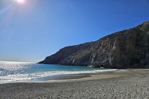 A pebbly beach with a rocky cliff and clear blue sea. - Villa in Pitsidia with swimming pool (Pitsidia)