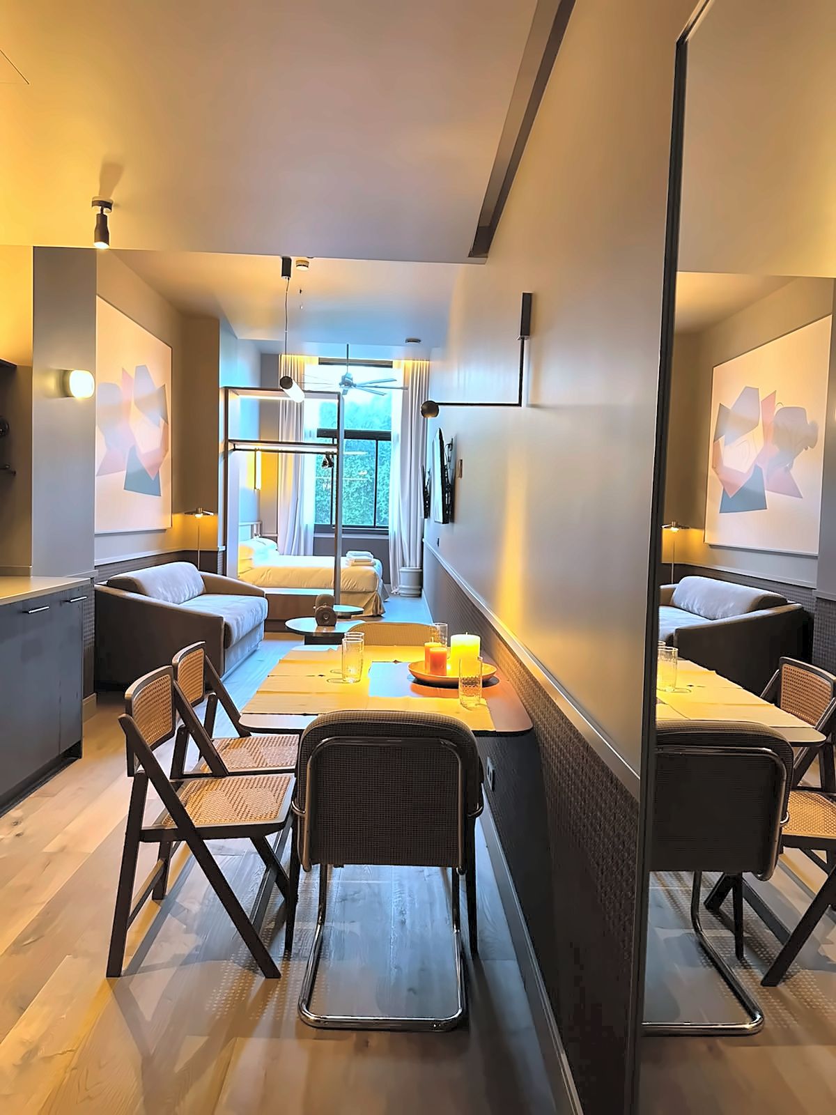 Een moderne hotelkamer met een eethoek, een bank en een bed.