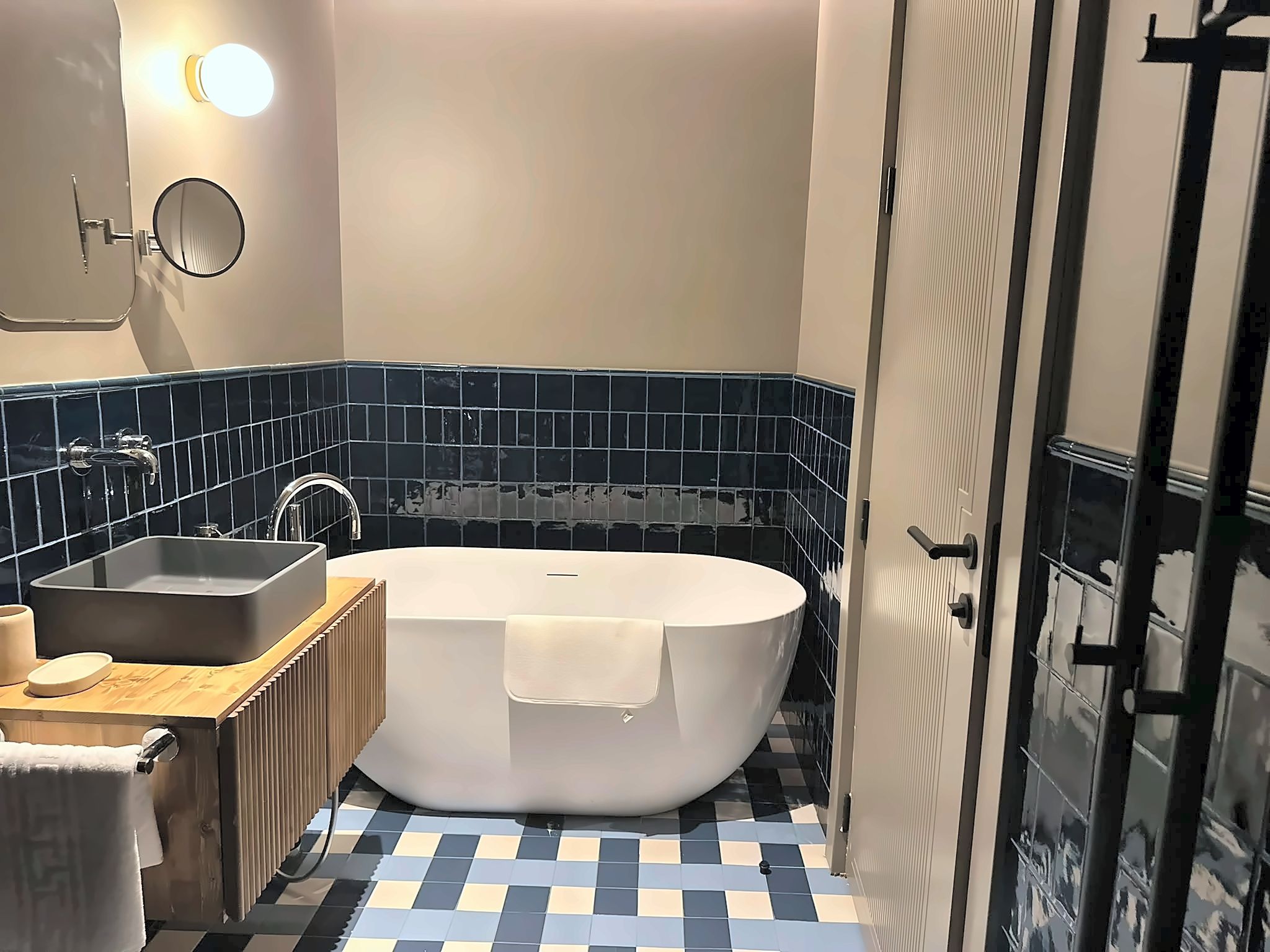 Ein modernes Badezimmer mit einer freistehenden Badewanne, einem Waschbecken und einem Spiegel.