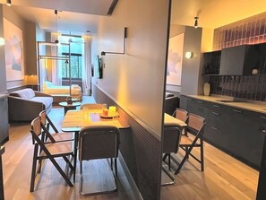 A modern interior with a dining area, kitchen, and seating space. - La Ría Urban Apartments (Bilbao)
