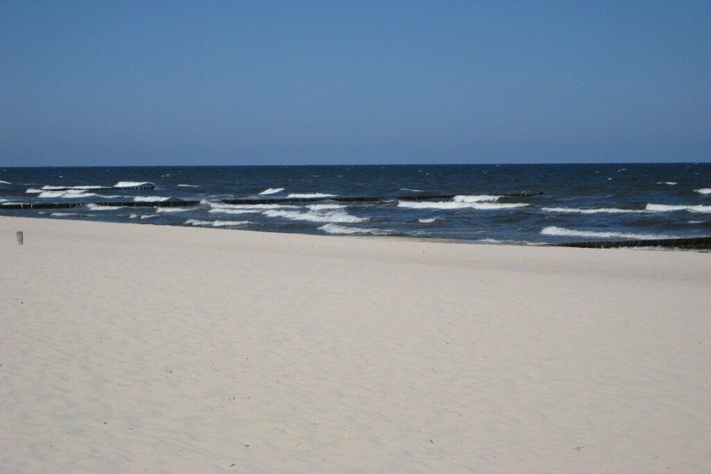 Ein Strand mit Wellen und blauem Himmel.