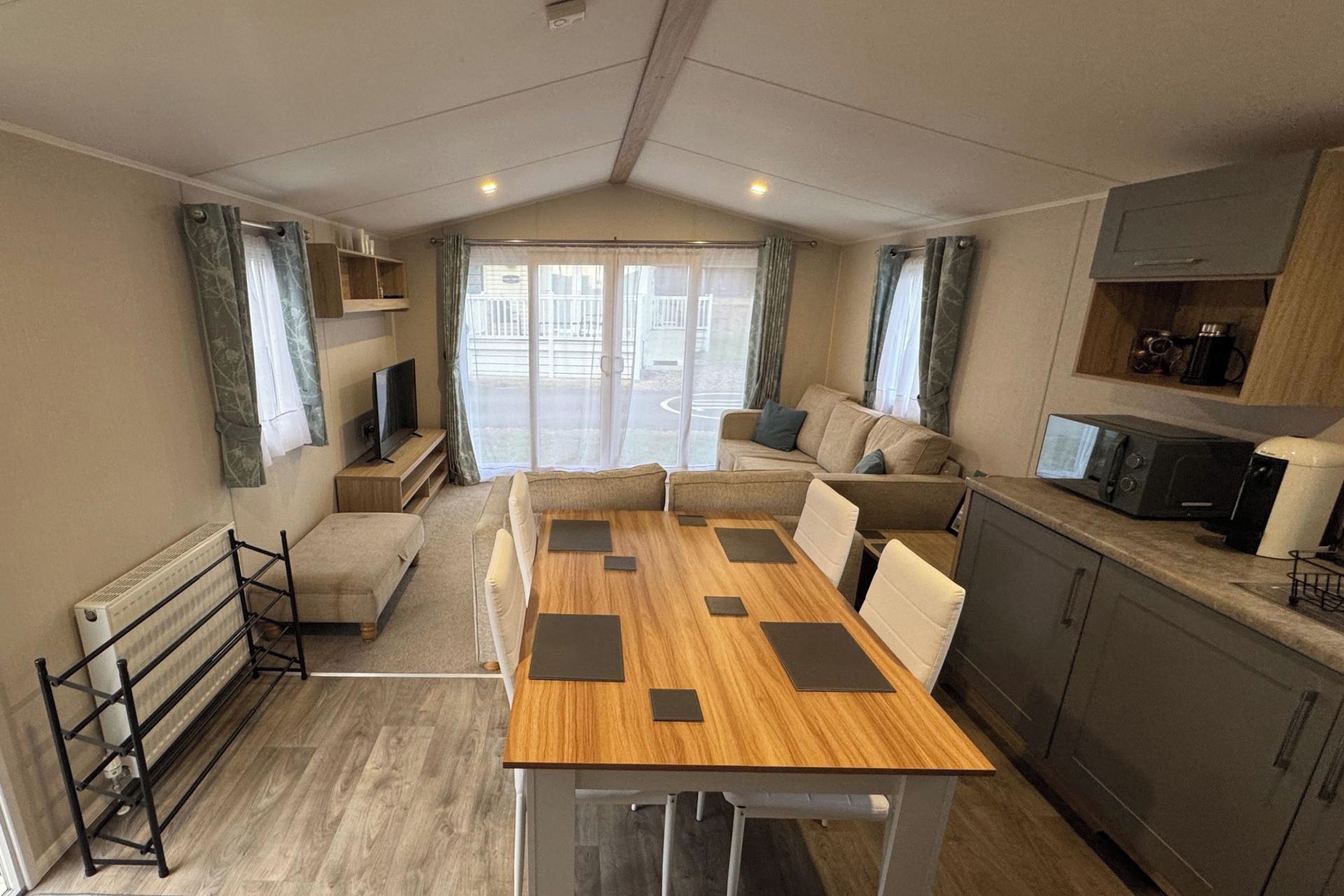 A compact living space with a kitchenette, a dining area, and a seating area with a view.