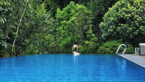 A swimming pool surrounded by lush greenery.