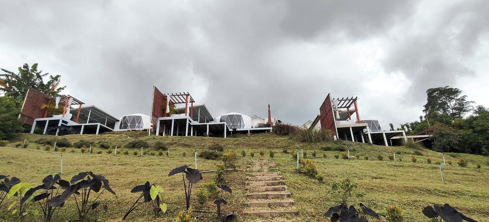 A modern building with a unique architectural design, featuring multiple levels and a prominent staircase leading to the entrance.