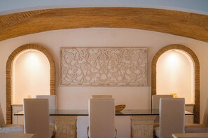 A dining area with a glass table, six chairs, and a decorative wall piece. - Portuguese mansion close to marina, golf and beach (Quarteira)