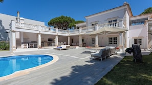 A large house with a swimming pool, outdoor seating, and a covered patio area. - Portuguese mansion close to marina, golf and beach (Quarteira)