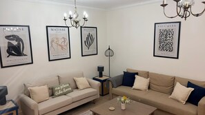 Un salon comprenant deux canapés, une table basse, une lampe et des œuvres d’art mural, notamment des créations de Matisse et de Paul Klee.