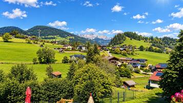Ein ländliches Dorf mit Häusern, einem Spielplatz und einem Berg im Hintergrund.