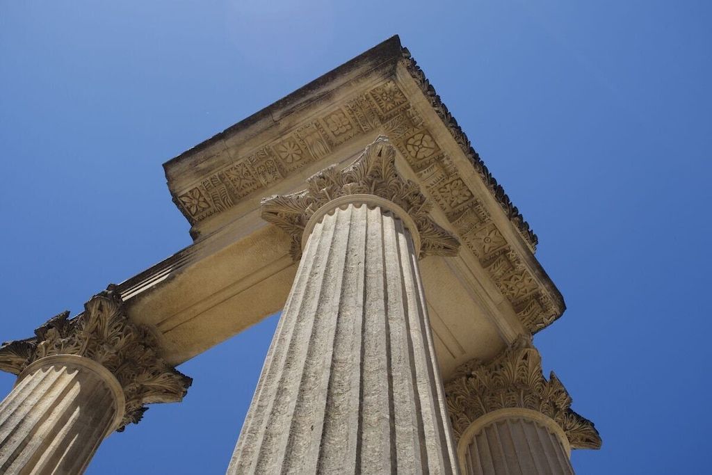 Une structure architecturale de style classique, dotée de colonnes corinthiennes et d’un décor de frise élaboré.