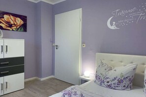A bedroom with a bed, a nightstand, a dresser, and a door. - The Fox's Den - SweetDreams (Bad Sachsa)