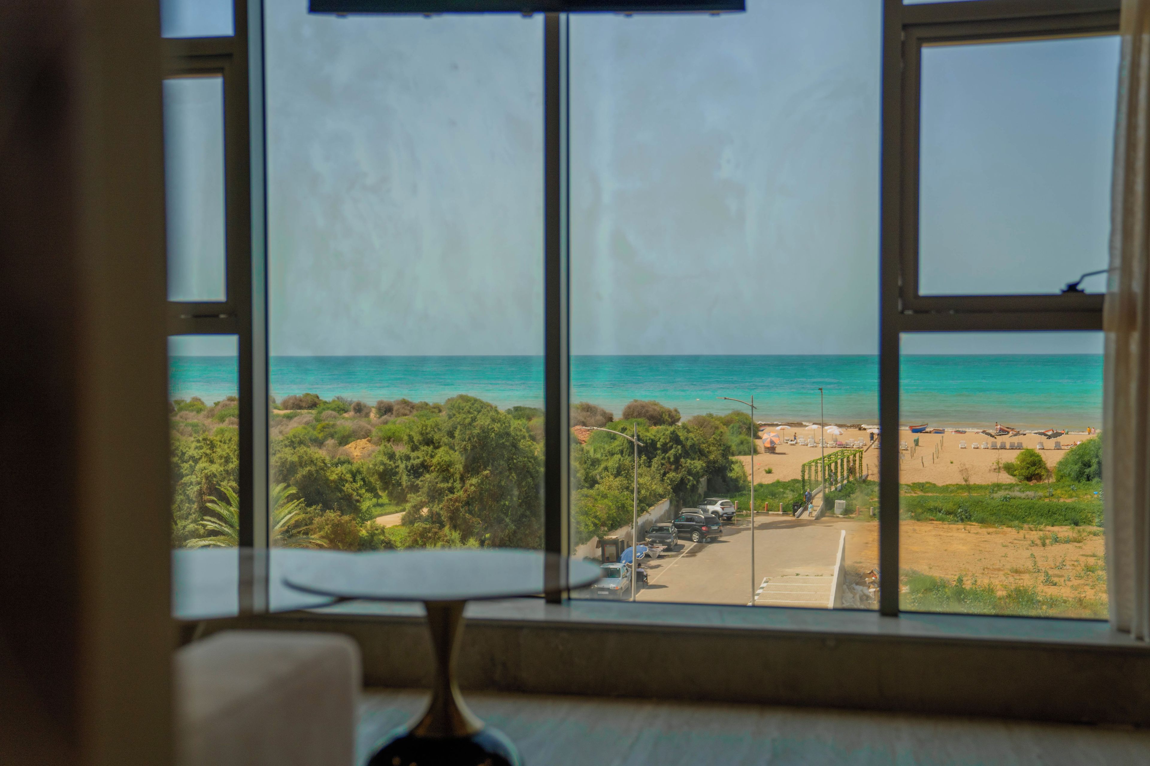 Ein Zimmer mit großem Fenster und Blick auf den Strand.