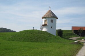 Ein weißer Turm mit einem spitzen Dach, einer Treppe und einer kleinen Tür.