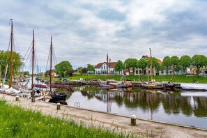 A marina with boats docked, a grassy area, and a building in the background. - Inn in Leezdorf with swimming pool (Leezdorf)