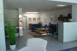 Un salon moderne avec un canapé, une table basse et une plante en pot.