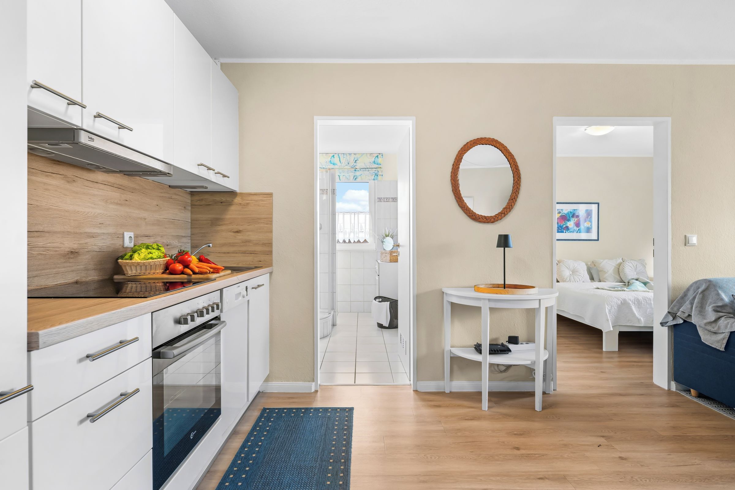A modern kitchen with white cabinets, a wooden countertop, and a built-in oven.