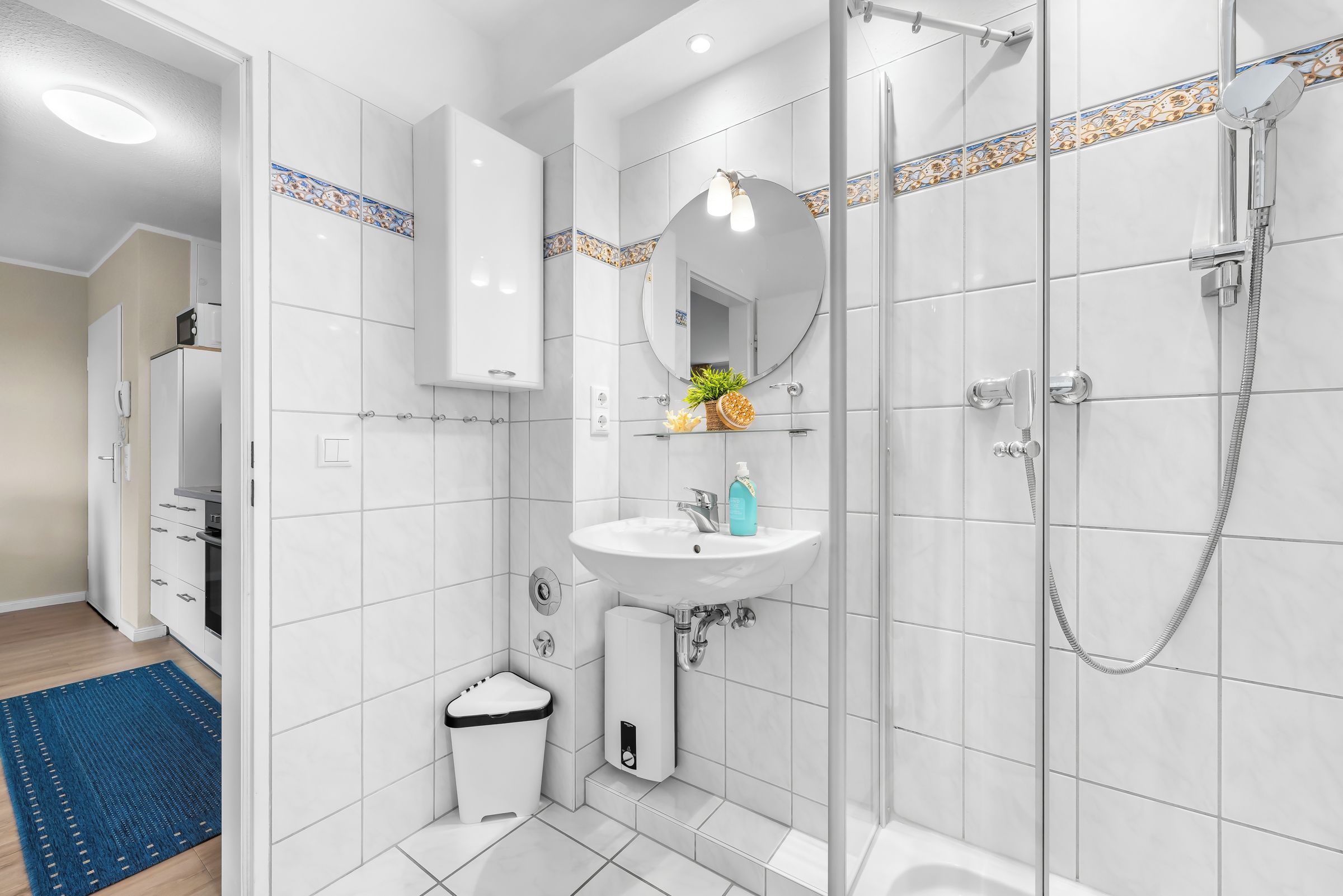 A modern bathroom with a shower, sink, and toilet.