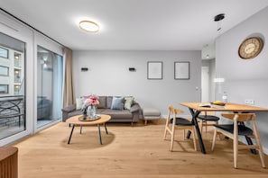 En moderne stue med sofa, sofabord og spiseplads.