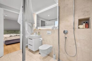 Ein modernes Badezimmer mit Dusche, Toilette und Waschbecken.