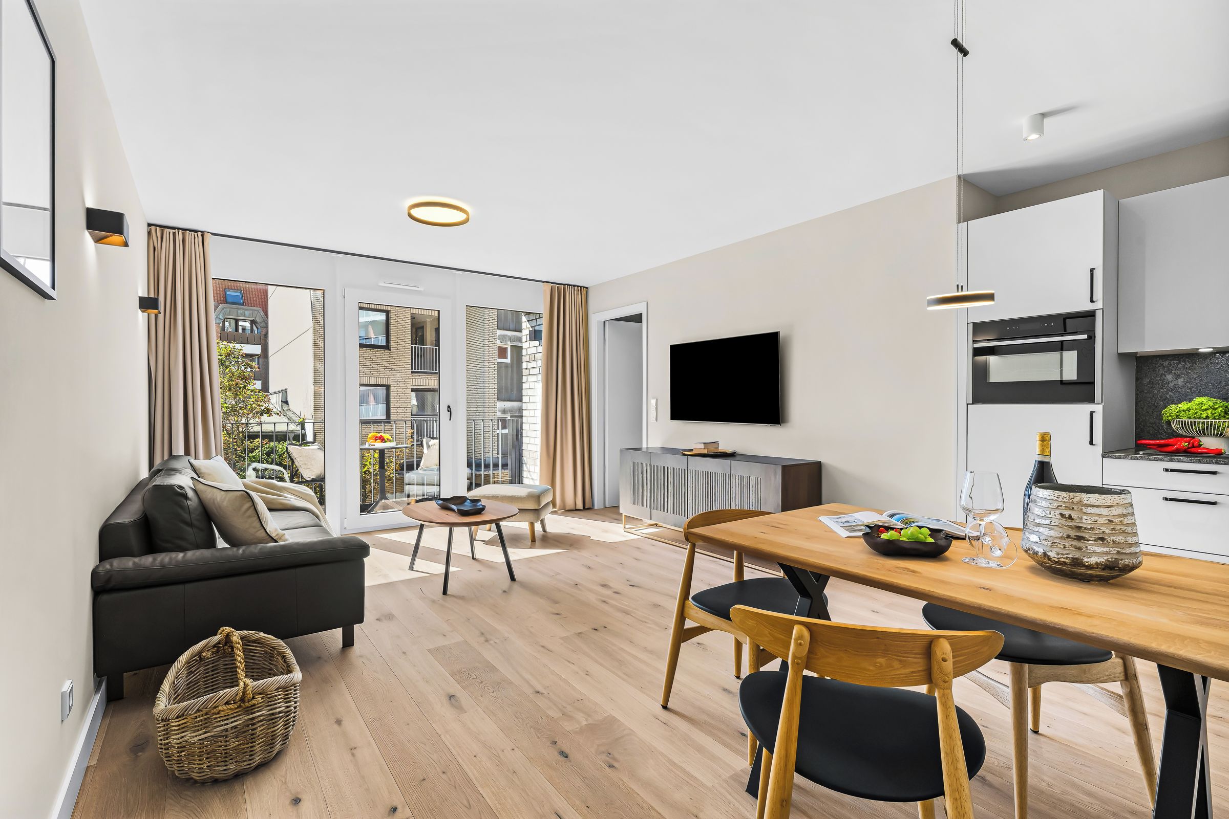 En moderne lejlighed med spiseplads, køkken og opholdsstue.