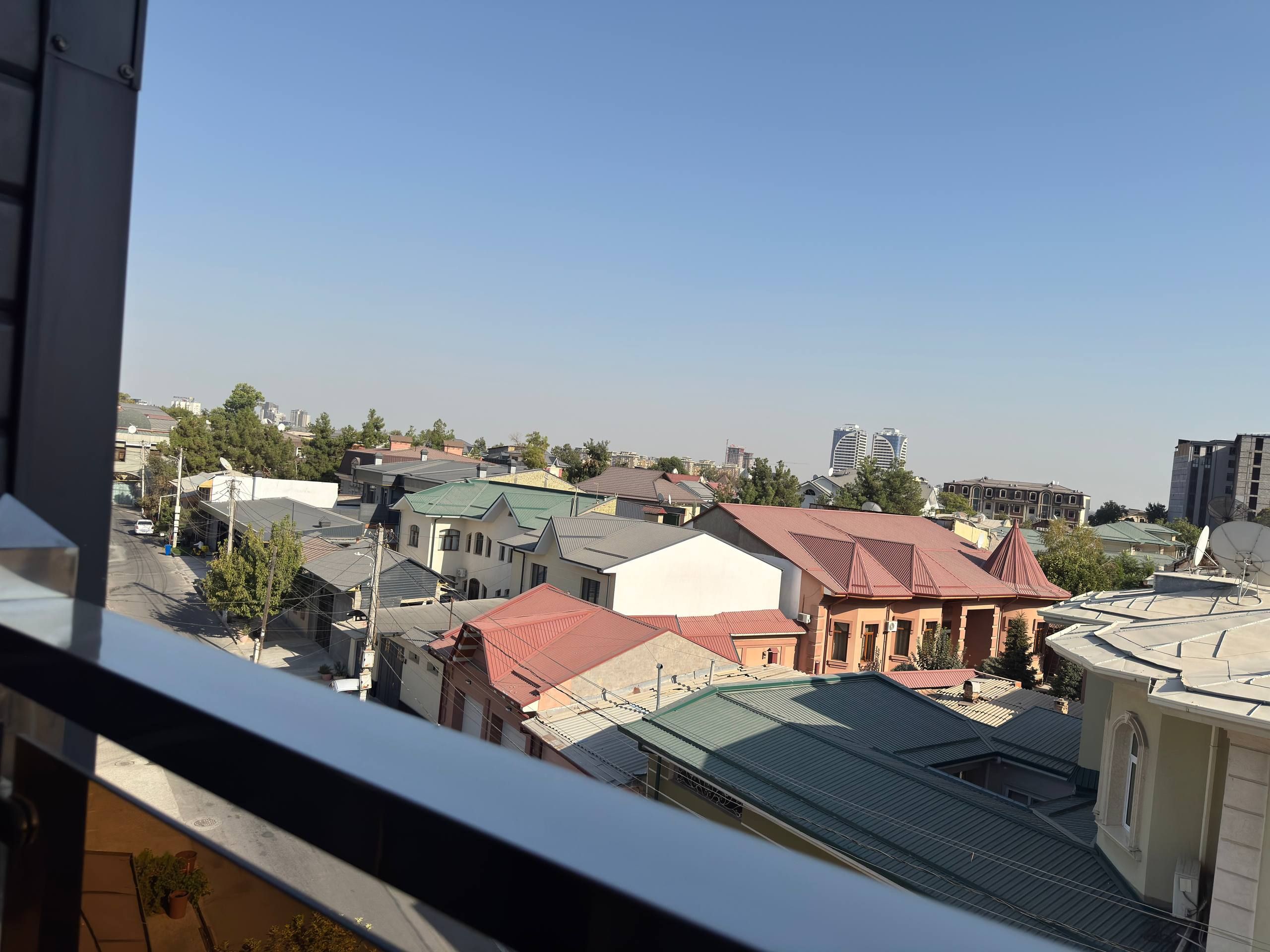 Una zona residencial con diversos edificios, incluyendo casas con techos de distintos colores y algunas estructuras altas a lo lejos.