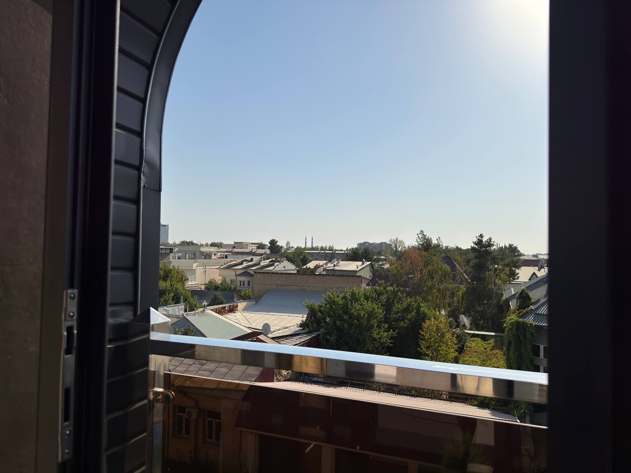 Vista desde una ventana que da a un barrio residencial con varios edificios y cielo despejado.