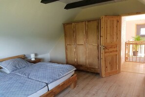 A bedroom with a bed, wooden wardrobe, and a nightstand. - Holiday home in Sörup with swimming pool (Sörup)