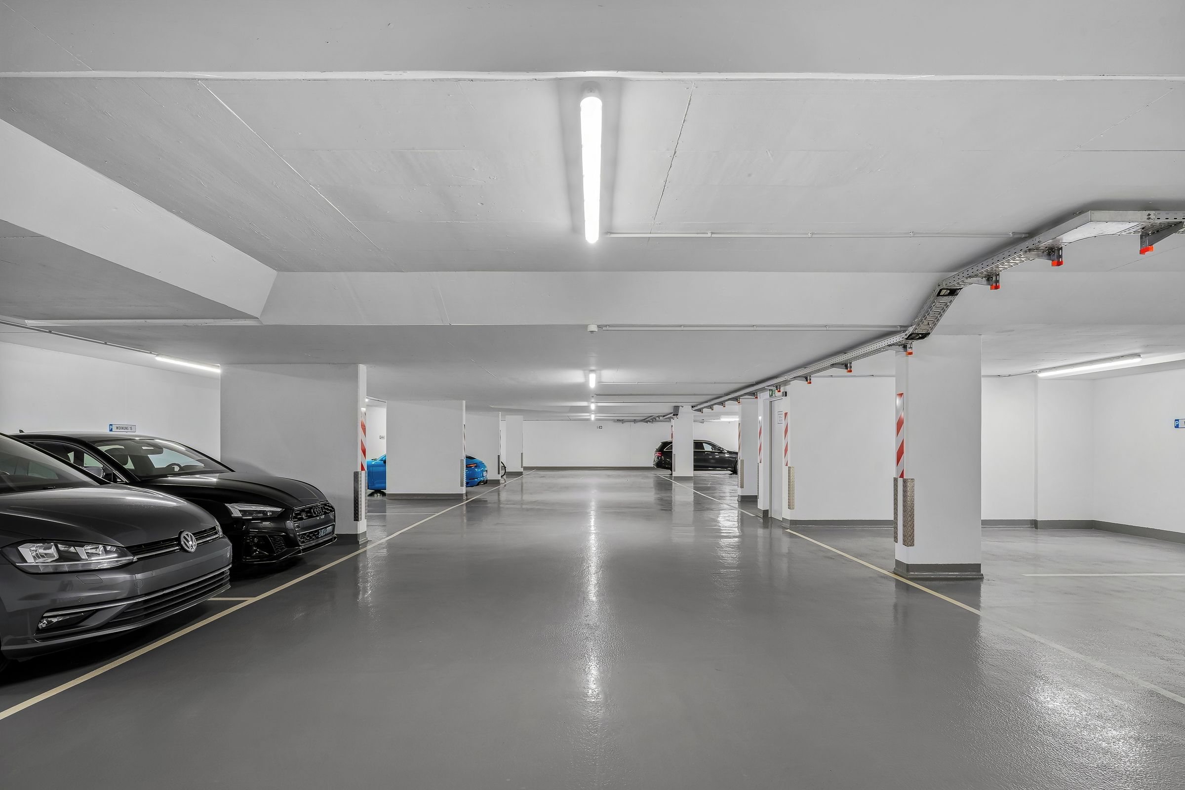 Eine Parkgarage mit mehreren Ebenen, gekennzeichneten Stellplätzen und einer sauberen, gut beleuchteten Umgebung.