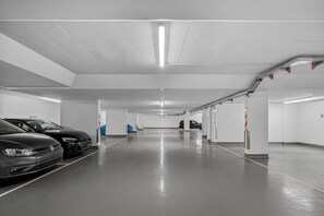 Uma garagem de estacionamento com vários níveis, vagas demarcadas e ambiente limpo e bem iluminado.